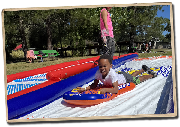 a camper speeding down the slip and slide toward the camera