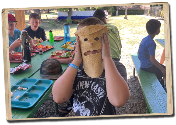 a camper in a johnny cash shirt holding up a tortilla mask to their face
