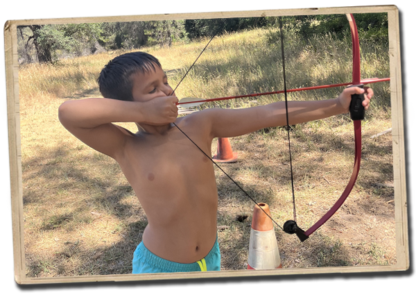 a camper ready to fire an arrow from his bow