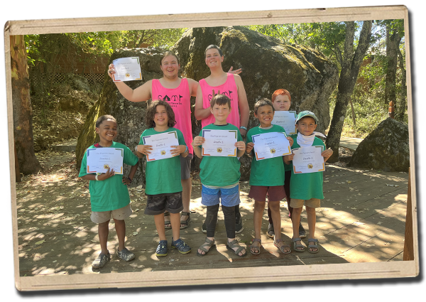 proud staff pose with campers receiving award certificates
